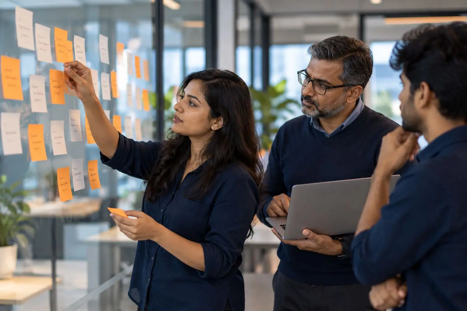 A team mapping website data with sticky notes on a glass wall
